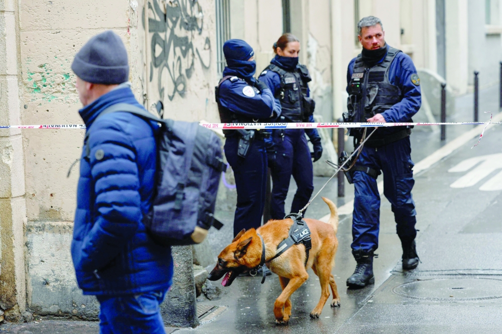 Police officers of the dog handling team stand outside French leftist party La France Insoumise (LFI) national headquarters, in Paris 