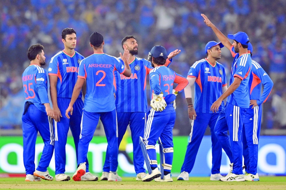 India's Varun Chakravarthy (C) celebrates with teammates after taking the wicket of Netherlands' Max O'Dowd during the 2026 ICC Men's T20 Cricket World Cup group stage match between India and Netherlands at the Narendra Modi Stadium in Ahmedabad