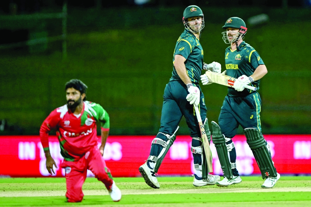 Australia's Travis Head (R) and captain Mitchell Marsh (C) run between the wickets during the 2026 ICC Men's T20 Cricket World Cup group stage match between Oman and Australia at Pallekele International Cricket Stadium in Kandy on February 20, 2026.  (Photo by Ishara S. KODIKARA / AFP)
