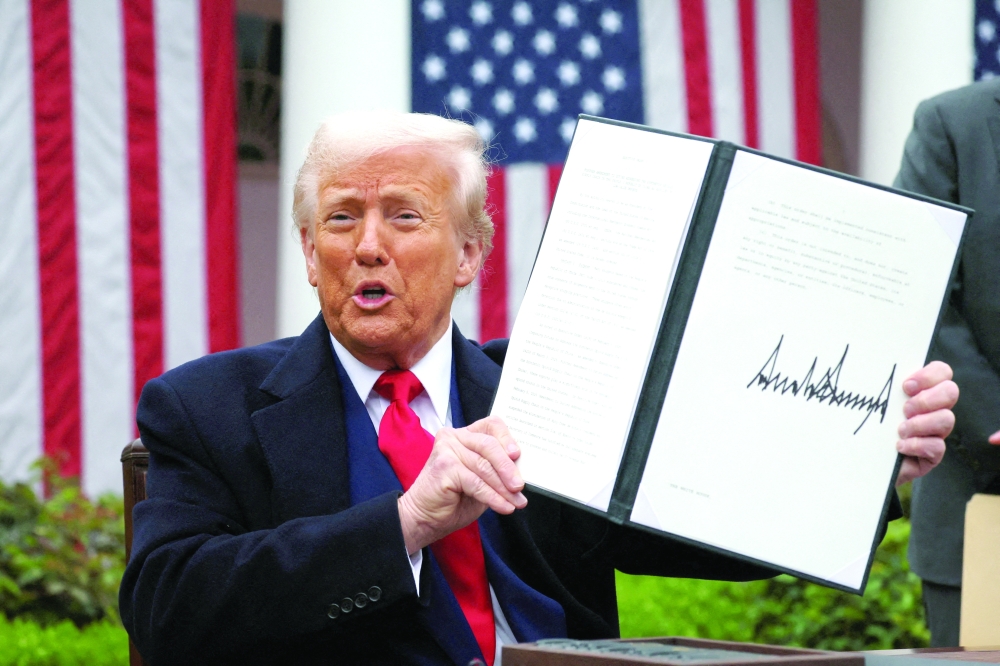 US President Donald Trump holds a signed executive order on tariffs, in the Rose Garden at the White House in Washington, DC. — Reuters File