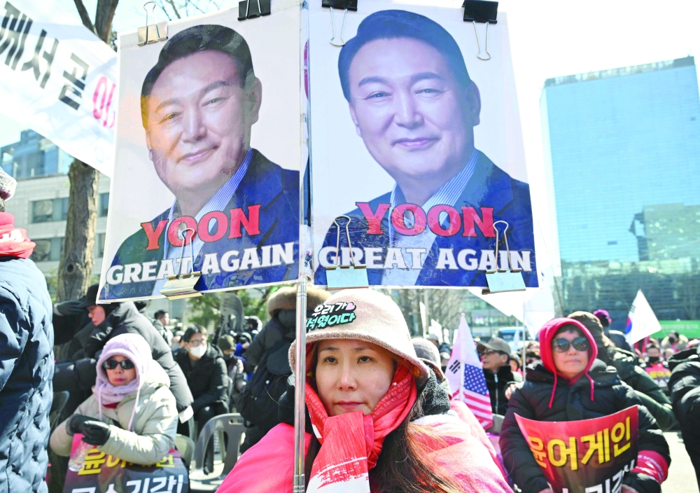 A supporter of South Korea's impeached former president Yoon Suk Yeol holds a placard as they gather in front of the Seoul Central District Court in Seoul. — AFP