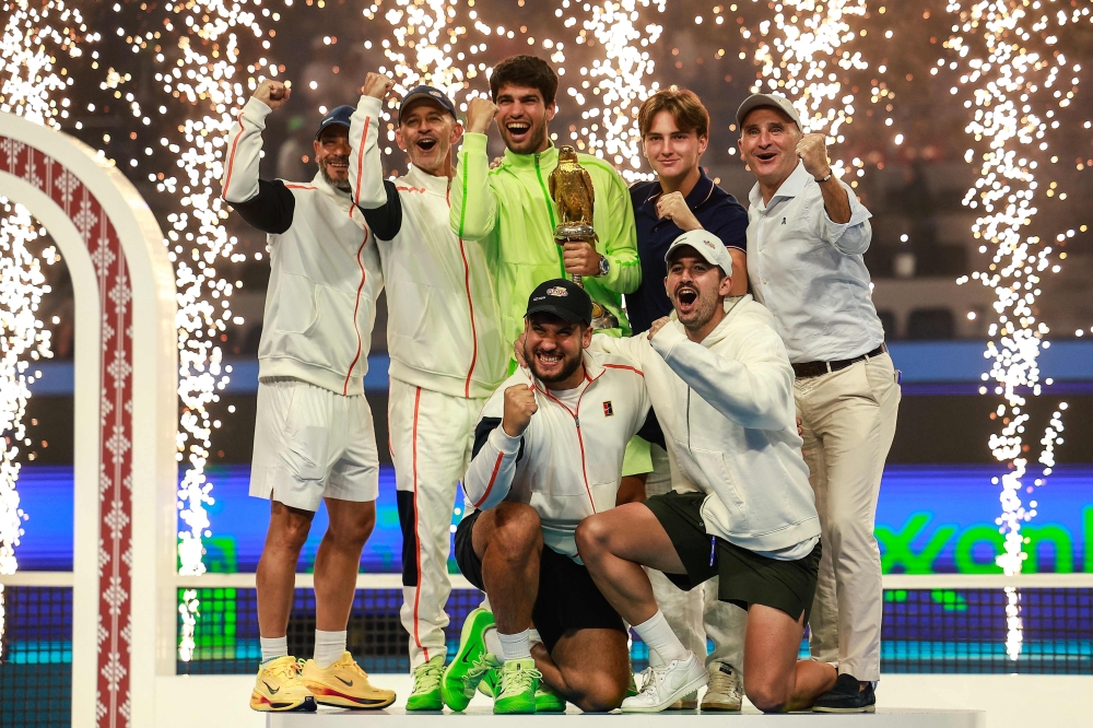 Spain's Carlos Alcaraz celebrates on the podium with teammates 