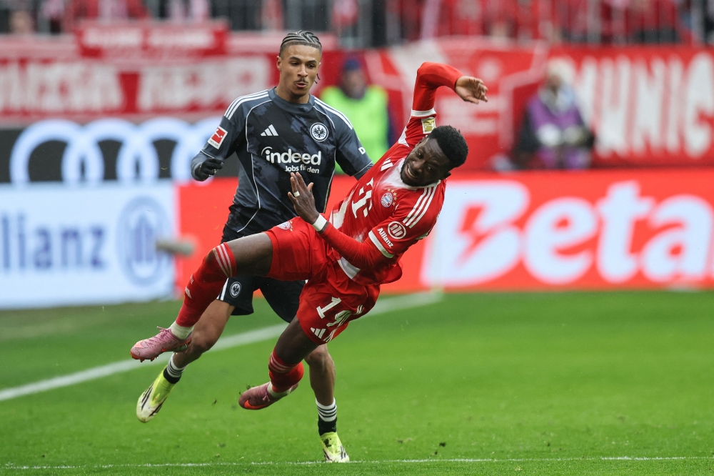 Bayern Munich #19 Alphonso Davies (R) is fgouled by Frankfurt #19 Jean-Matteo Bahoya 