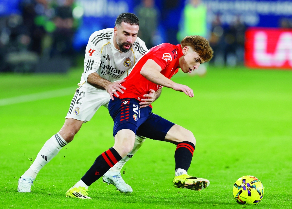 Real Madrid's Dani Carvajal in action with Osasuna's Victor Munoz. —  Reuters