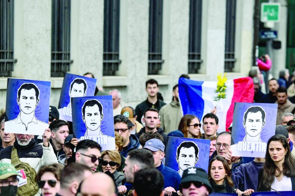 Protesters hold portraits of far-right activist Quentin Deranque during a march, in Lyon. — AFP