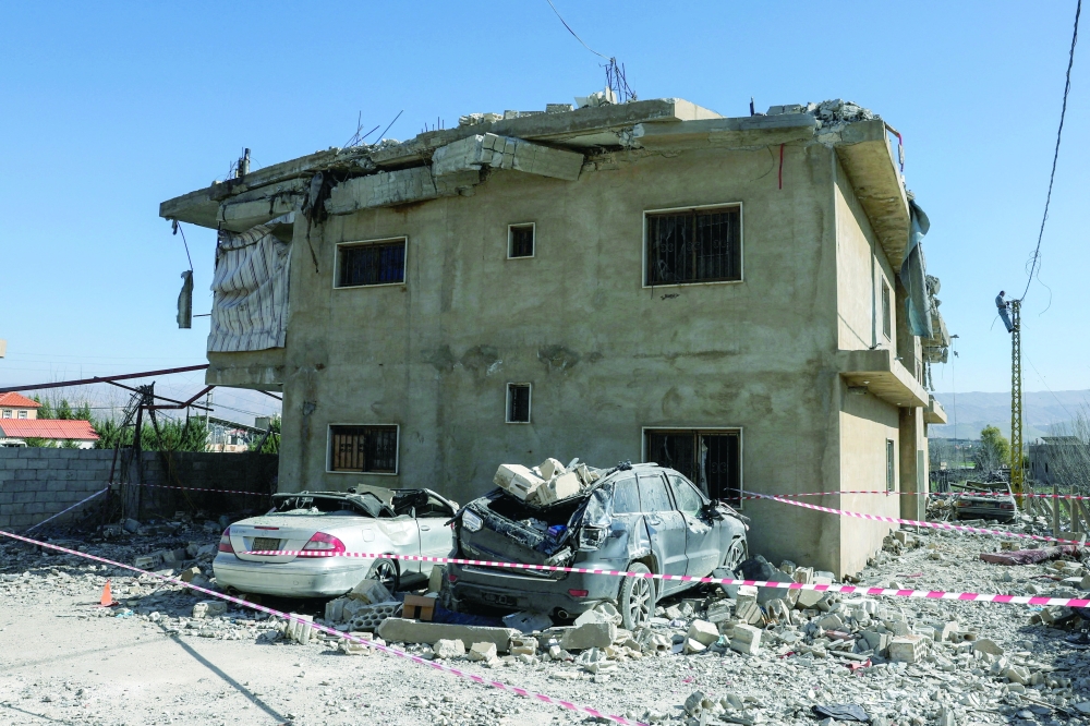 Destroyed vehicles lie next to a damaged building, in the aftermath of an Israeli strike, in Bekaa valley. — Reuters