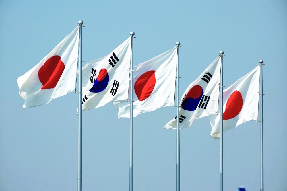 A view of South Korean and Japanese national flags hoisted, at Tokyo International Airport. — Reuters 
