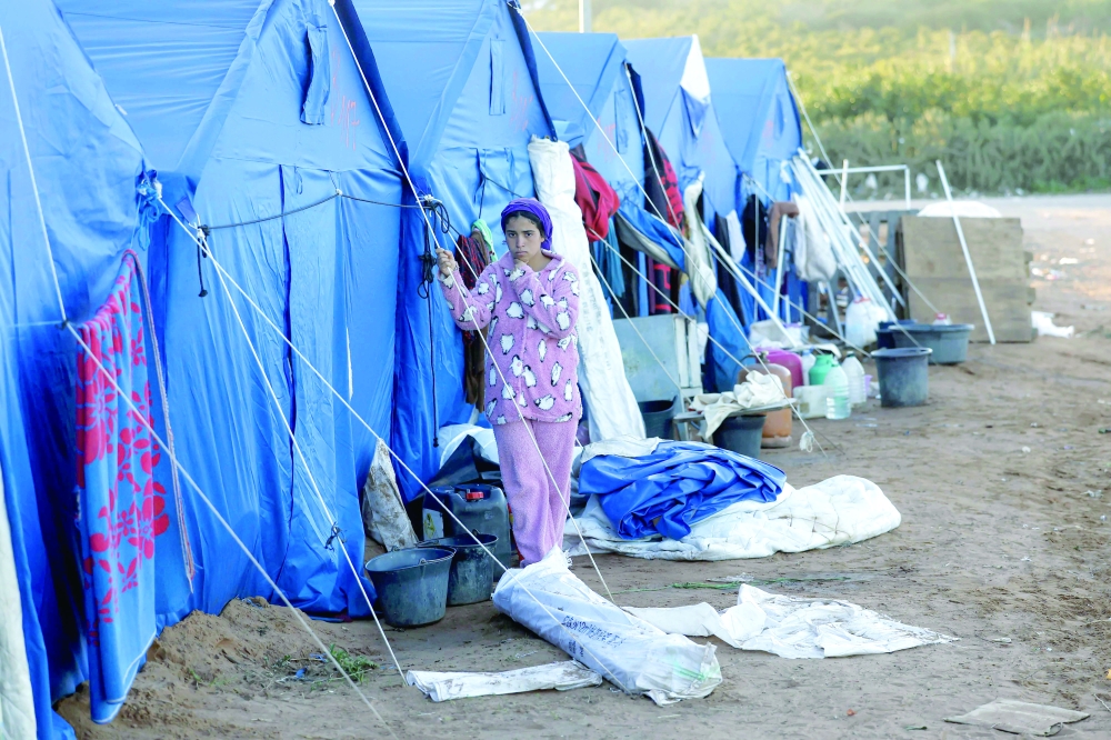 A girl walks outside tent shelters at a relief camp for those affected by floods that struck northern and western Morocco, in the Kenitra region on February 20, 2026.  (Photo by Abdel Majid BZIOUAT / AFP)
