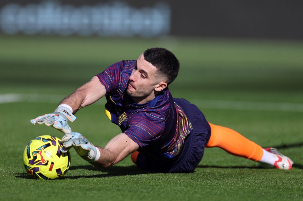 Barcelona's Spanish goalkeeper #13 Joan Garcia warms up  