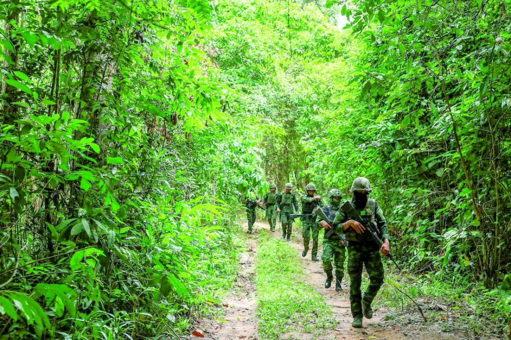 Thai military personnel walk near the forested disputed border with Cambodia. — Reuters