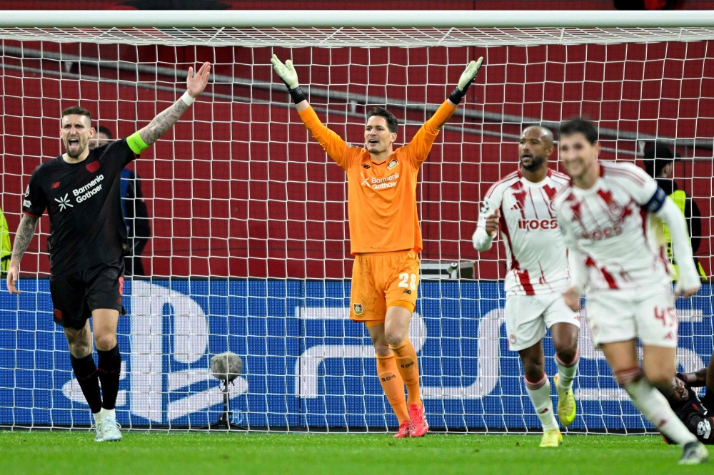Bayer Leverkusen's German goalkeeper #28 Janis Blaswich (C) and Bayer Leverkusen's German midfielder #08 Robert Andrich (L) 