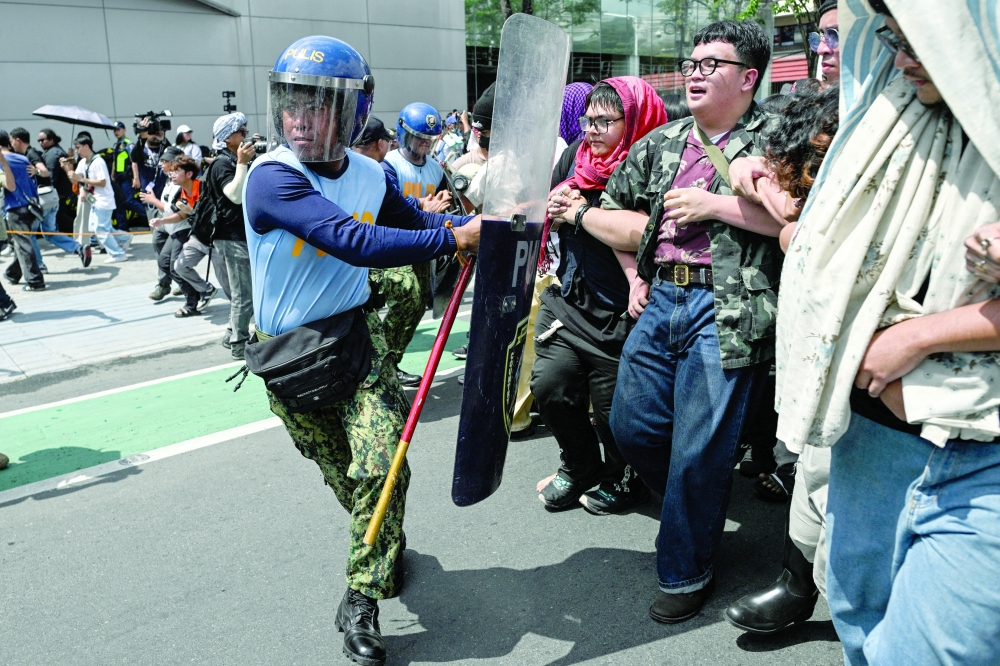 Demonstrators scuffle with policemen during a protest commemorating the 40th anniversary of the 1986 People Power Revolution that overthrew the late dictator Ferdinand Marcos, near the EDSA Shrine, in Quezon City, Metro Manila, Philippines, February 25, 2026. REUTERS/Noel Celis