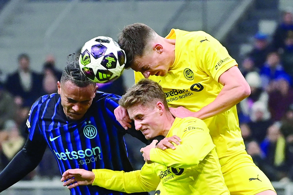TOPSHOT - Inter Milan's Swiss defender #25 Manuel Akanji (L) heads the ball challenged by Bodo/Glimt's Norwegian midfielder #20 Fredrik Sjovold and Bodo/Glimt's Norwegian forward #26 Hakon Evjen (R) during the UEFA Champions League second-leg play-off football match between Inter Milan and Bodo/Glimt at San Siro stadium in Milan, northern Italy, on February 24, 2026.  (Photo by PIERO CRUCIATTI / AFP)
