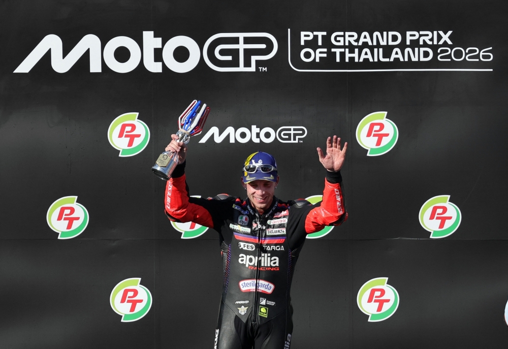 Aprilia Racing's Marco Bezzecchi celebrates winning the MotoGP race on the podium  