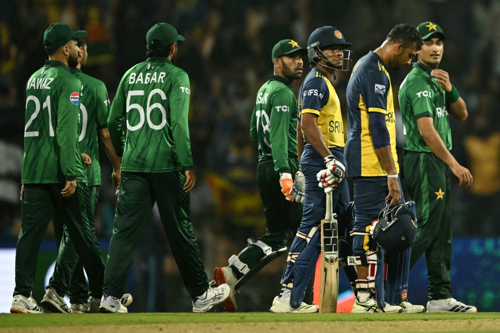 Sri Lanka's captain Dasun Shanaka (2R) and Dunith Wellalage (3R) walk back to the pavilion as Pakistan's Naseem Shah (R) looks on  