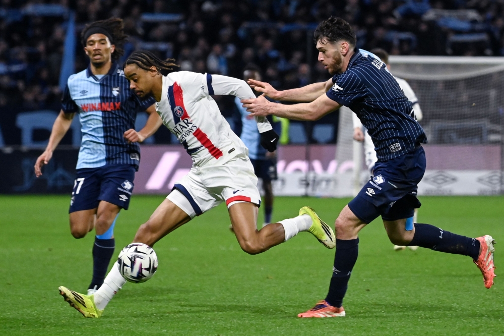 Paris Saint-Germain's French forward #29 Bradley Barcola (C) fights for the ball with Le Havre's French defender #04 Gautier Lloris (R)  