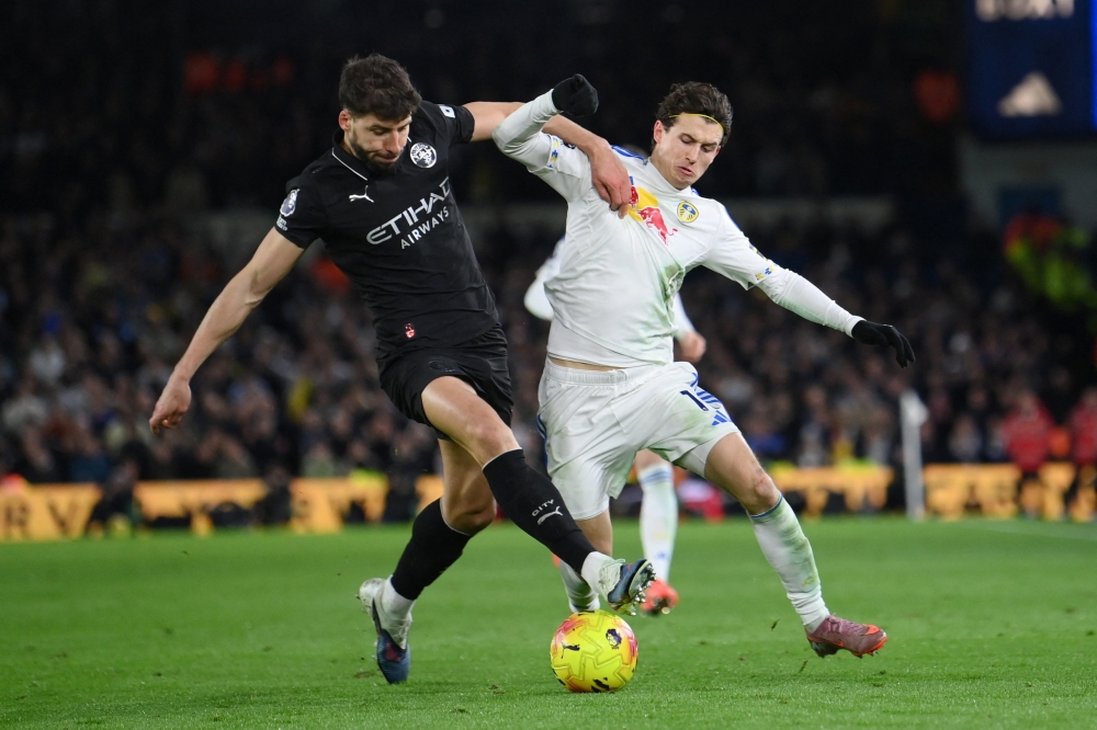   Manchester City's Ruben Dias in action with Leeds United's Brenden Aaronson  