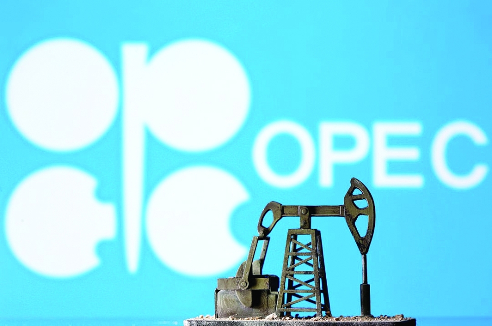 A 3D printed oil pump jack is seen in front of displayed Opec logo in this illustration picture. — Reuters
