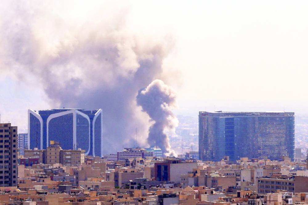 Plumes of smoke rise following reported explosions in Tehran. — AFP
