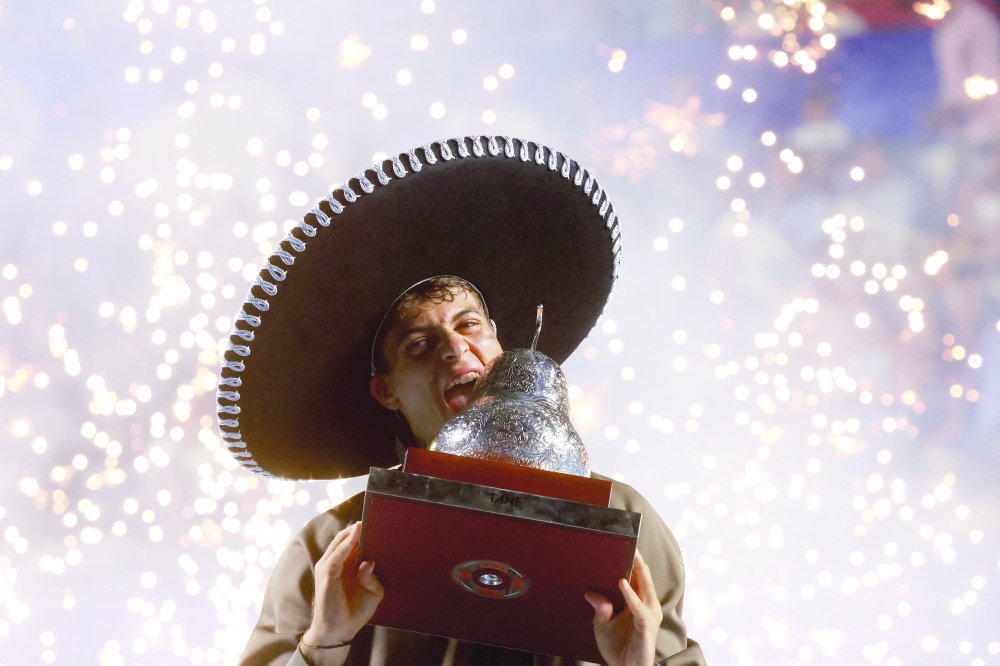 Italy's Flavio Cobolli celebrates with the trophy after winning his final match against Frances Tiafoe of the U.S. 