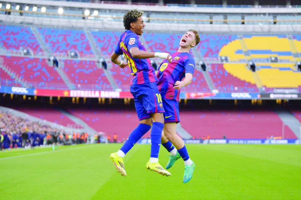 TOPSHOT - Barcelona's Spanish forward #10 Lamine Yamal celebrates scoring the opening goal with Barcelona's Spanish midfielder #16 Fermin Lopez during the Spanish league football match between FC Barcelona and Villarreal CF at Camp Nou Stadium in Barcelona on February 28, 2026. (Photo by MANAURE QUINTERO / AFP)
