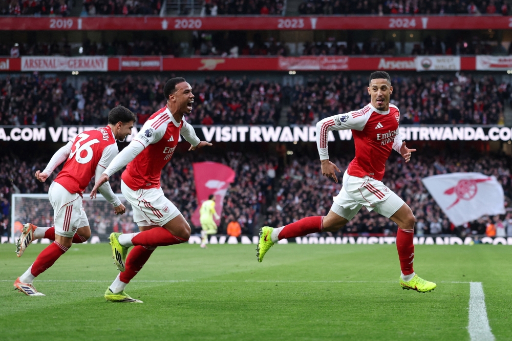 Arsenal's William Saliba celebrates scoring their first goal with Gabriel Magalhaes and Martin Zubimendi 