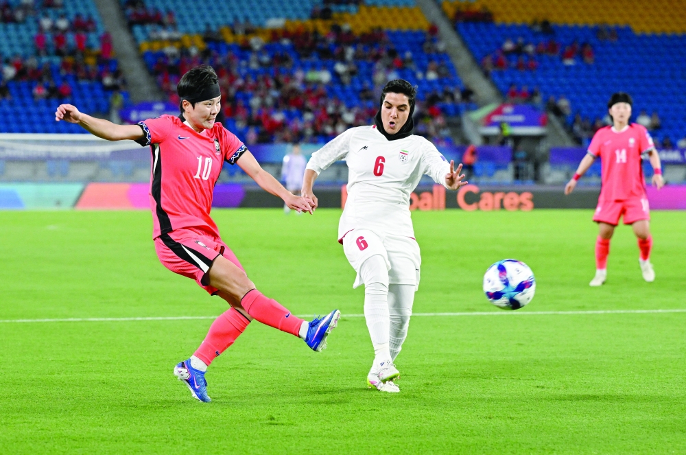 Ji So-yun of South Korea takes a shot at goal past Zahra Sarbali of Iran during the AFC Women’s Asian Cup. — Reuters
