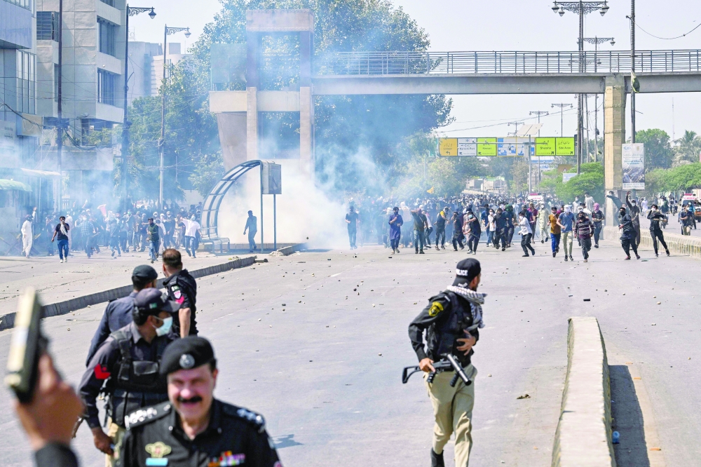 Security personnel fire tear gas as protesters gather outside the US consulate in Karachi. — AFP