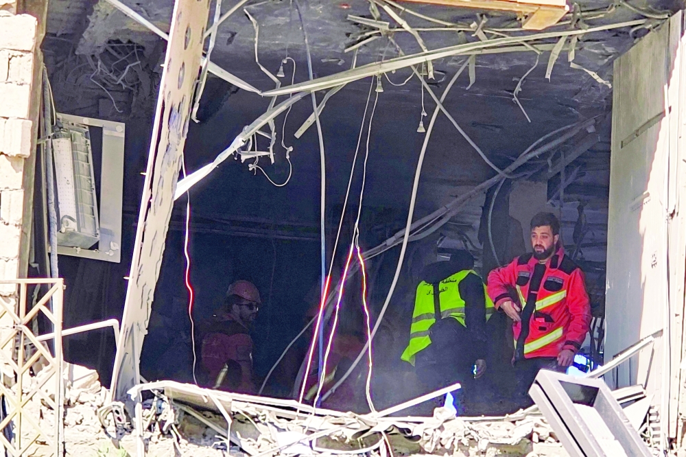 First responders inspect a building damaged in an Israeli air strike in the southern suburb of Beirut. — AFP