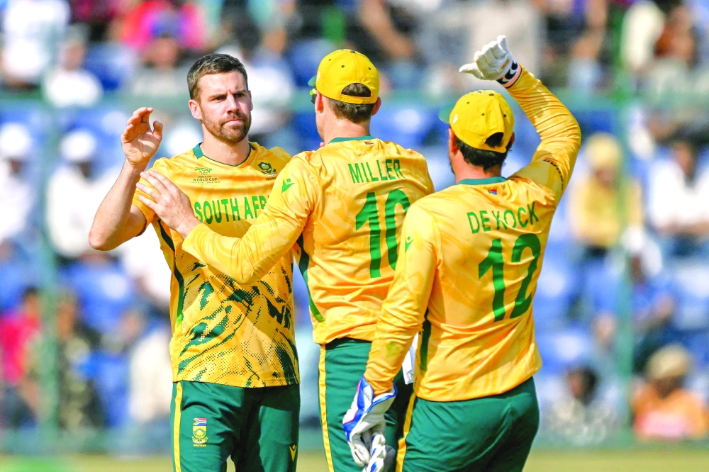 South Africa's Anrich Nortje (L) celebrates with teammates after taking the wicket of Zimbabwe's Brian Bennett during Super Eights match at the Arun Jaitley Stadium
