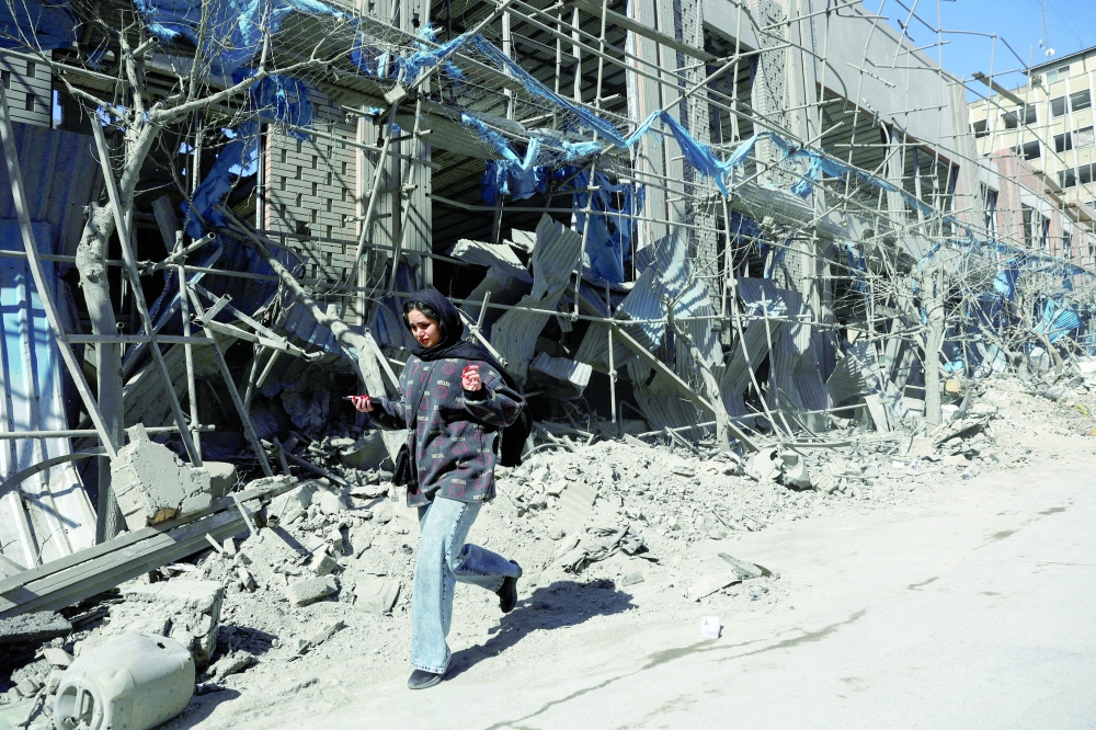 A woman walks on a street following an Israeli and US strike on a police station in Tehran, Iran, on Tuesday. - Reuters