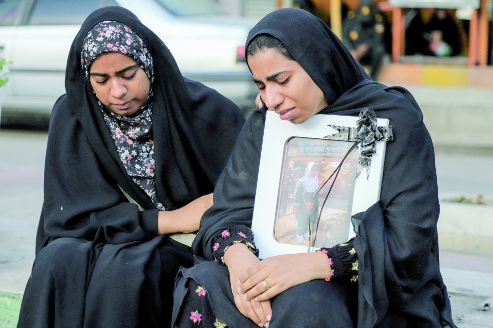 People mourn on the day of the funeral of the victims following a reported strike on a school in Minab, Iran, on Wednesday. - Reuters