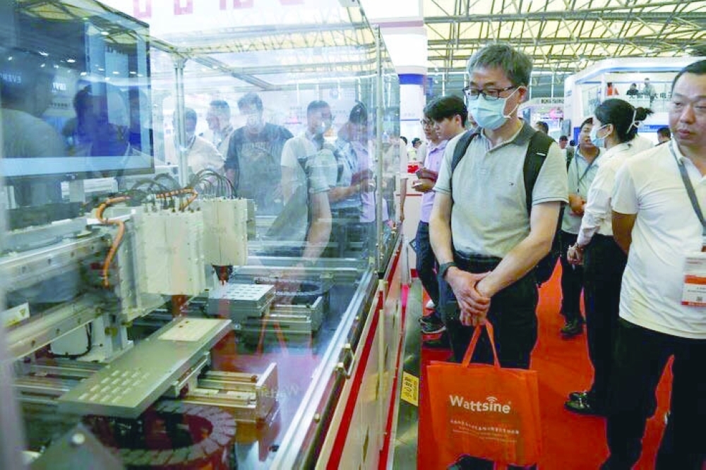 Visitors look at manufacturing equipment displayed at the THK booth during Semicon China, a trade fair for the semiconductor industry, in Shanghai, China. REUTERS