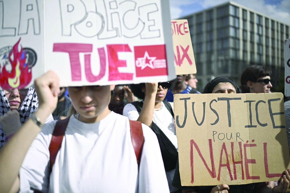 Protesters hold banners during a gathering marking two years since the death of Nahel Merzouk, a 17-year-old shot dead at point-blank by police during a traffic stop, in Nanterre, west of Paris. - AFP File