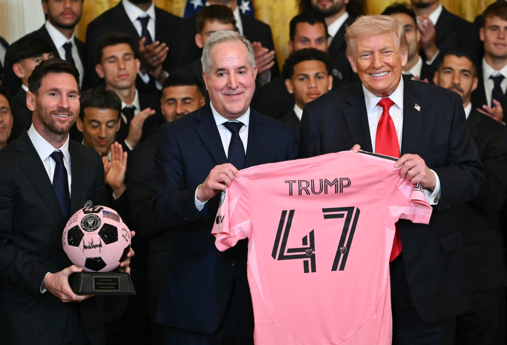 IInter Miami's Argentine forward Lionel Messi, Inter Miami's managing owner Jorge Mas and US President Donald Trump pose with a 47 jersey and a signed ball 