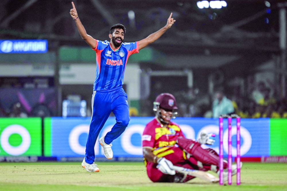 TOPSHOT - India's Jasprit Bumrah (L) celebrates after taking the wicket of West Indies' Shimron Hetmyer (bottom) during the 2026 ICC Men's T20 Cricket World Cup Super Eights match between India and West Indies at the Eden Gardens in Kolkata on March 1, 2026.  (Photo by Arun SANKAR / AFP)
