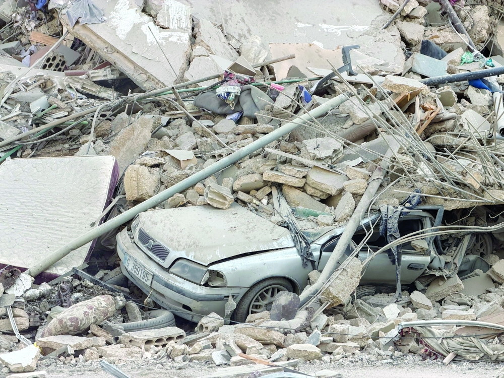 A vehicle lies under the rubble after an Israeli strike on Beirut's southern suburbs on Friday. — Reuters