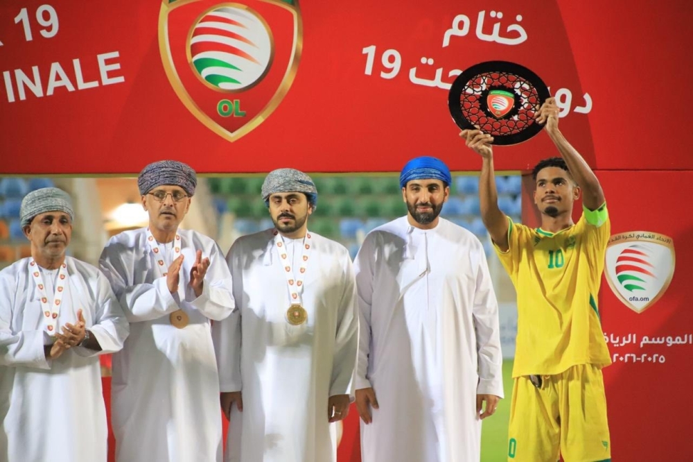Seeb captain celebrates with the trophy on the podium