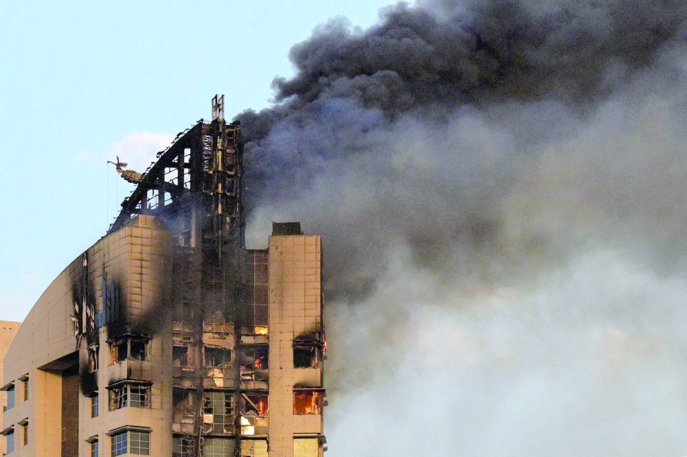 Smoke rises from a high-rise building following a drone attack in Kuwait City. — AFP