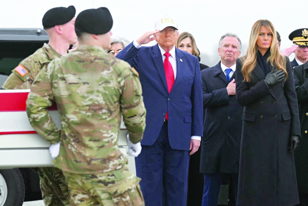 US President Donald Trump salutes as members of a US Army team carry the flag-draped transfer case containing the remains of a US soldier during a dignified transfer solemn event at Dover Air Force Base. — AFP