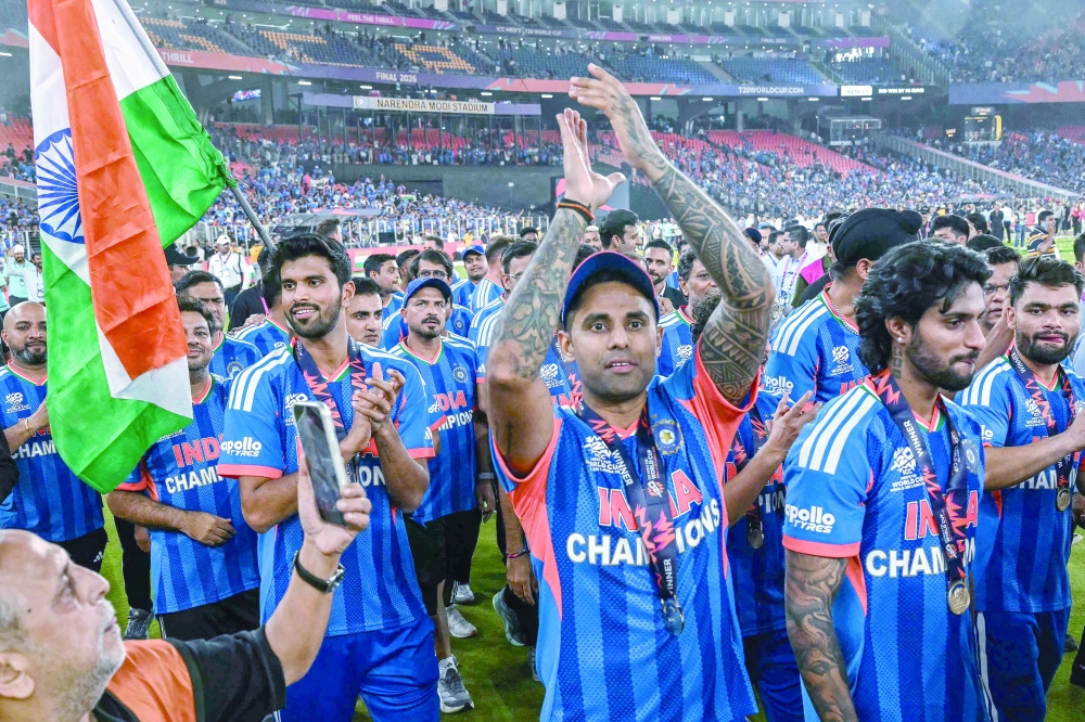 India's captain Suryakumar Yadav (C) and his teammates celebrate during a victory lap after winning the 2026 ICC Men's T20 Cricket World Cup final match against New Zealand at the Narendra Modi Stadium in Ahmedabad on March 8, 2026. (Photo by Punit PARANJPE / AFP)
