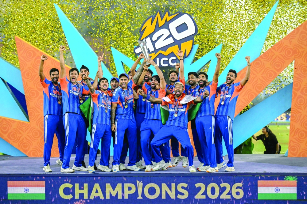 India's players celebrate with the trophy after winning the 2026 ICC Men's T20 Cricket World Cup final match against New Zealand at the Narendra Modi Stadium in Ahmedabad on March 8, 2026. (Photo by Punit PARANJPE / AFP)
