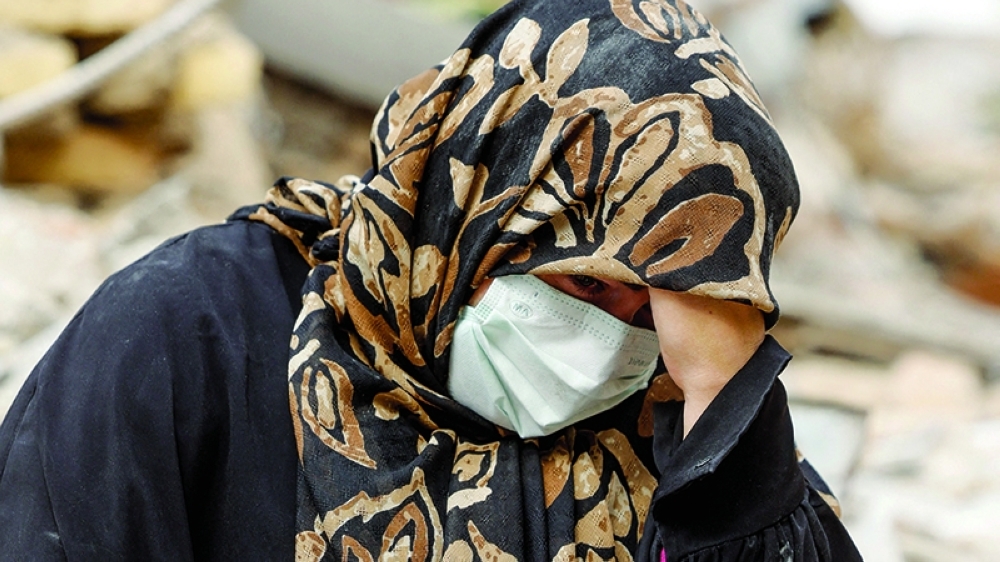 A woman sits outside her destroyed apartment after it was damaged by an air strike in Tehran, Iran, on Thursday. — Reuters