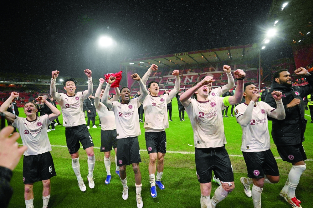 Midtjylland players celebrate in front of fans after the UEFA Europa League round of 16, first leg football match between Nottingham Forest and FC Midtjylland at The City Ground in Nottingham, central England, on March 12, 2026. Midtjylland won the match 1-0. (Photo by Oli SCARFF / AFP)

