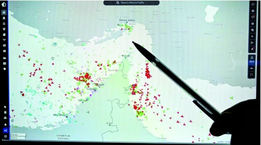 A person points at a page on the Marinetraffic website that shows commercial traffic on the edge of the Strait of Hormuz on March 4. — AFP