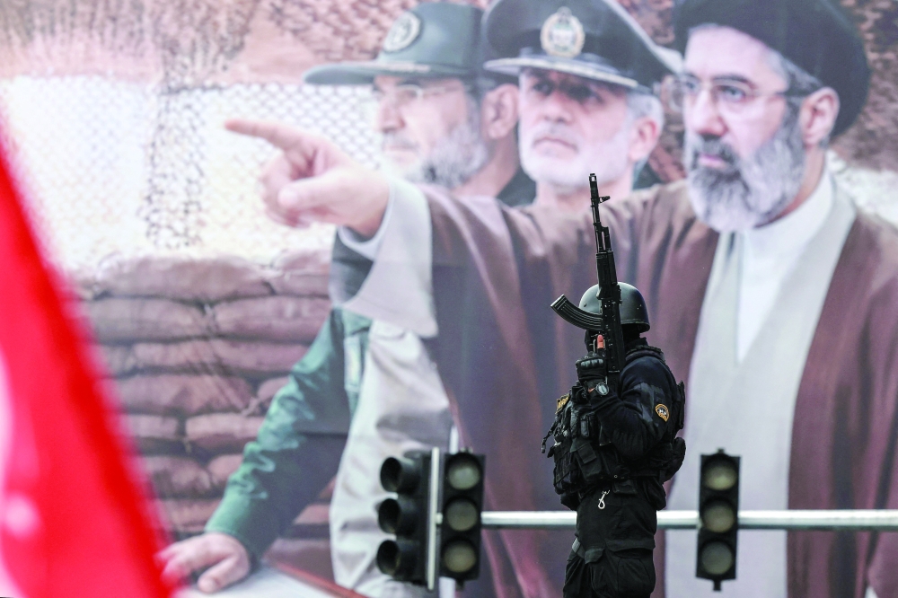 An Iranian security force officer stands guard next to a huge billboard of Iran's supreme leader Ayatollah Mojtaba Khamenei during Al Quds (Jerusalem) Day rally in support of the Palestinians on the last Friday of Ramadhan, in Tehran. — AFP