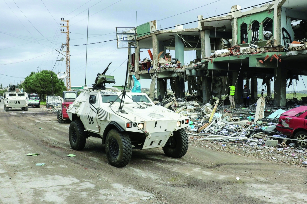 UN peacekeepers drive past a destroyed healthcare centre building, in southern Lebanese. — AFP