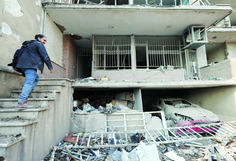 An Iranian man goes into his house, which was destroyed by an Israeli strike in Tehran on Saturday. — Reuters