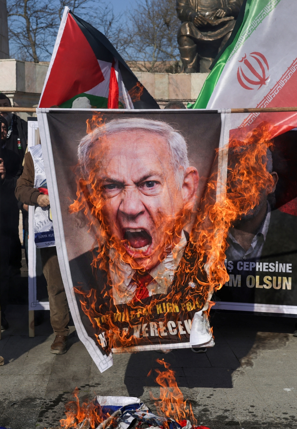 Demonstrators set a banner with an image of Israeli Prime Minister Benjamin Netanyahu on fire during a rally to mark the al-Quds Day after Friday prayers in Istanbul, Turkey, March 13, 2026. REUTERS/Murad Sezer