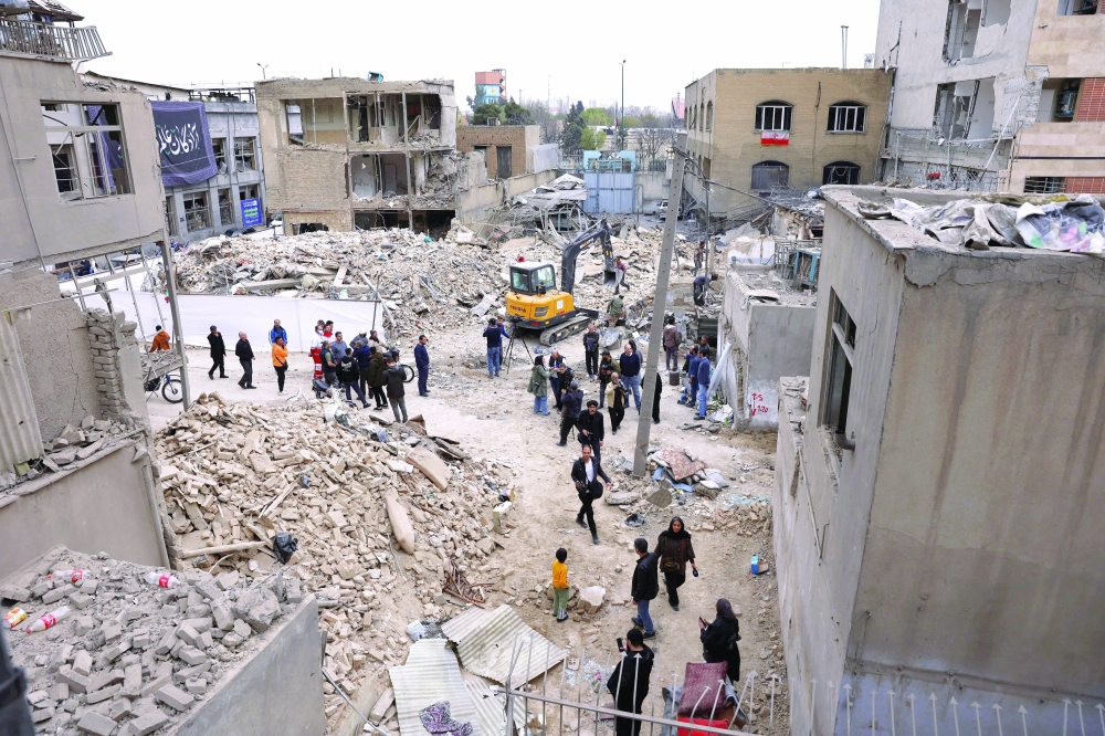 People walk at the site of a strike, amid the US-Israeli conflict with Iran, in Tehran. — Reuters